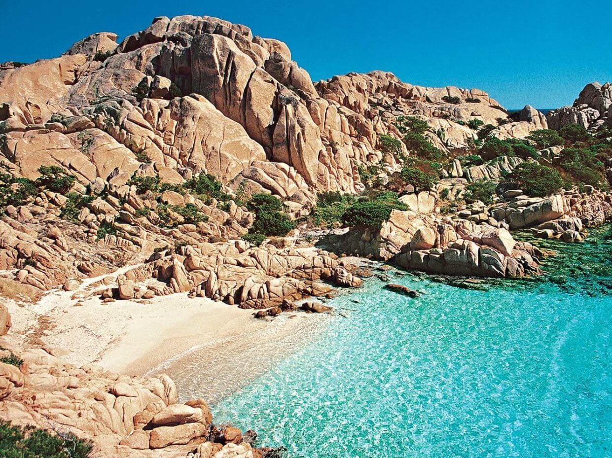 Cala Coticcio avec eaux turquoise entourée de rochers en Sardaigne