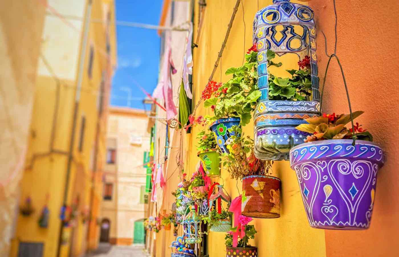 Rue étroite d’Olbia décorée de pots colorés suspendus en Sardaigne
